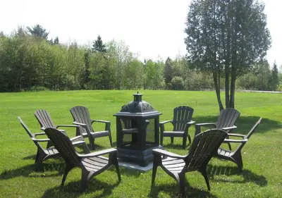 a group of chairs around a fire hydrant in a field at Motel de la Pente Douce in Magog-Orford