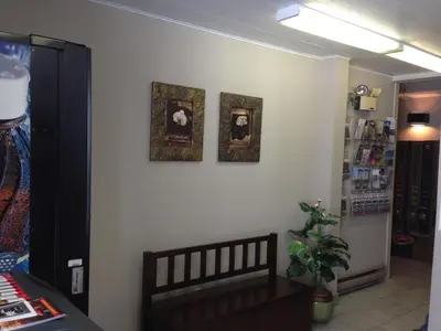 a room with three pictures on a white wall at Motel de la Pente Douce in Magog-Orford