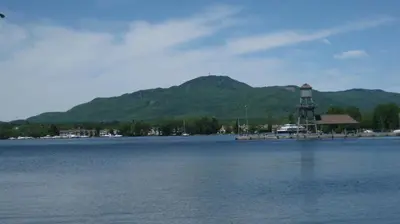 a large body of water with a mountain in the background at Motel de la Pente Douce in Magog-Orford