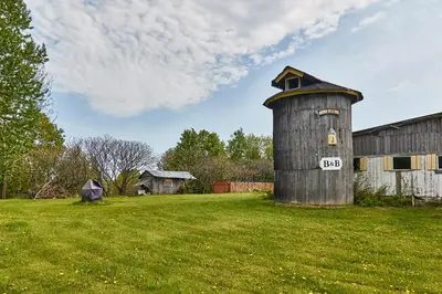 an old barn and a silo in a field at Auberge de la Tour et Spa in Magog-Orford