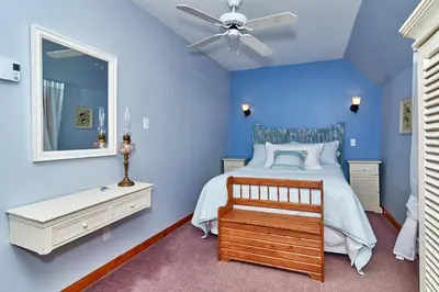 a blue bedroom with a bed and a ceiling fan at Auberge de la Tour et Spa in Magog-Orford