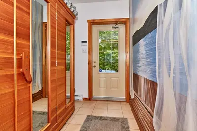 a hallway with a door with a painting on the wall at Auberge de la Tour et Spa in Magog-Orford