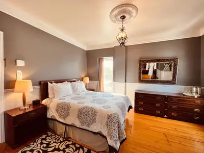 a bedroom with a bed and a dresser and a mirror at Le Chateau du Lac in Magog-Orford