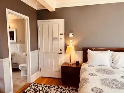 a bedroom with a bed and a bathroom with a toilet at Le Chateau du Lac in Magog-Orford