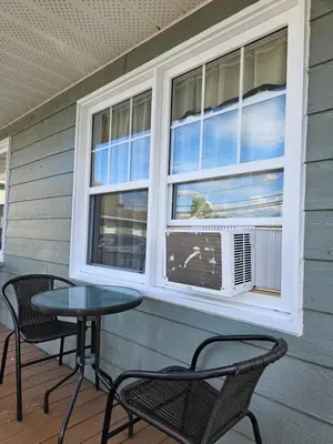 a patio with two chairs and a table and a window at Motel de l'Outlet in Magog-Orford