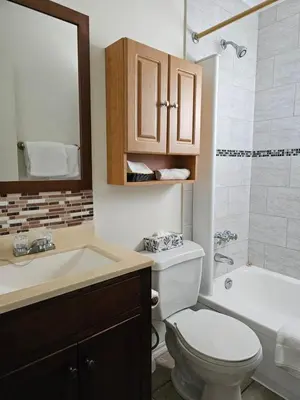 a bathroom with a toilet and a sink and a tub at Motel de l'Outlet in Magog-Orford