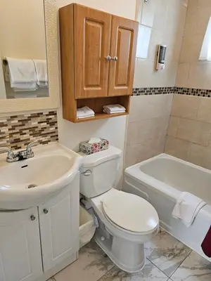 a bathroom with a toilet and a sink and a tub at Motel de l'Outlet in Magog-Orford