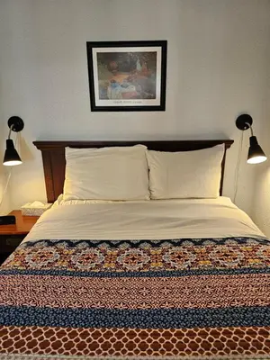 a bedroom with a bed with two lamps and a picture at Motel de l'Outlet in Magog-Orford