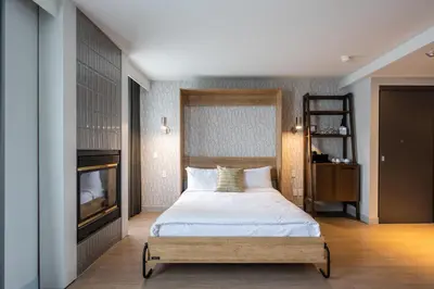 a bedroom with a bed and a fireplace at Hôtel Versō in Magog-Orford