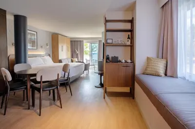 a hotel room with a bed and a table and chairs at Hôtel Versō in Magog-Orford