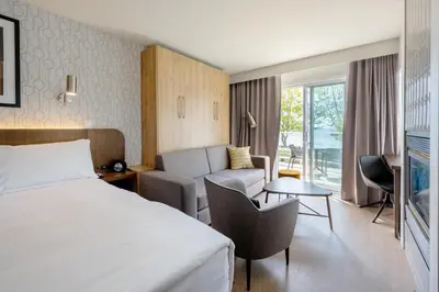 a hotel room with a bed and a couch at Hôtel Versō in Magog-Orford