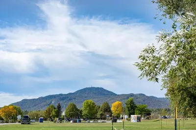 a park with a mountain in the background at Hôtel Versō in Magog-Orford