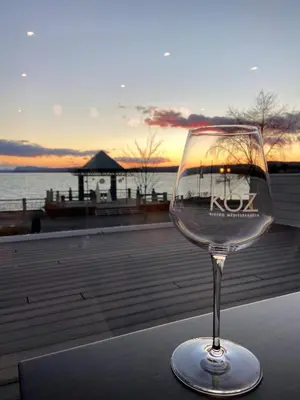 a wine glass sitting on a table in front of the ocean at Hôtel Versō in Magog-Orford