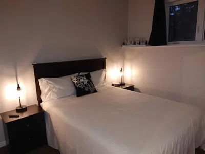 a bedroom with a large white bed with two lamps at Au pied des pentes in Bromont