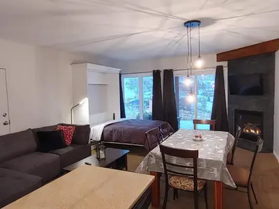 a living room with a couch and a bed at Au pied des pentes in Bromont