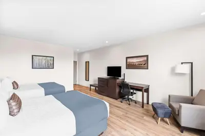 a hotel room with a bed and a desk at Best Western Plus Montreal East in Montréal