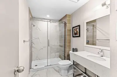 a bathroom with a shower and a toilet and a sink at Best Western Plus Montreal East in Montréal