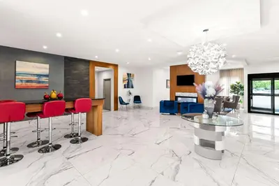 a living room with a table and red chairs at Best Western Plus Montreal East in Montréal