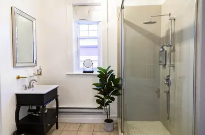 a bathroom with a shower and a sink and a mirror at Manoir Becancourt Hotel in Bécancour