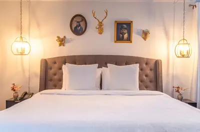 a bedroom with a large bed with white sheets at Manoir Becancourt Hotel in Bécancour