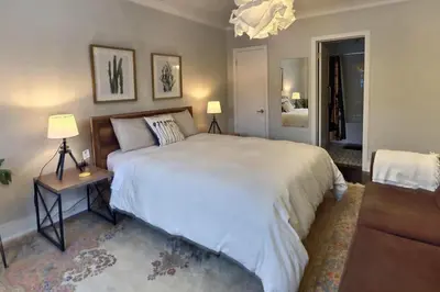 a bedroom with a large white bed and two lamps at Gite du Survenant Montreal in Montréal