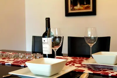 a bottle of wine sitting on a table with two glasses at Gite du Survenant Montreal in Montréal