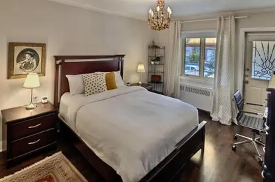a bedroom with a large bed and a chandelier at Gite du Survenant Montreal in Montréal