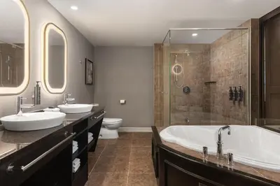 a bathroom with two sinks and a shower at Hotel Vallea Bromont, Tapestry Collection by Hilton in Bromont