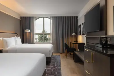 a hotel room with two beds and a desk at Hotel Vallea Bromont, Tapestry Collection by Hilton in Bromont