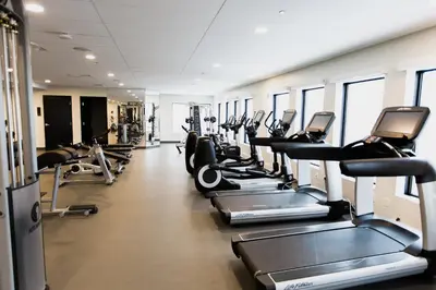 a gym with a row of treadmills and ellipticals at Espace 4 Saisons in Magog-Orford