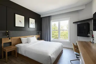a bedroom with a bed and a desk and a window at Espace 4 Saisons in Magog-Orford