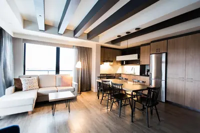a living room with a couch and a table and chairs at Espace 4 Saisons in Magog-Orford