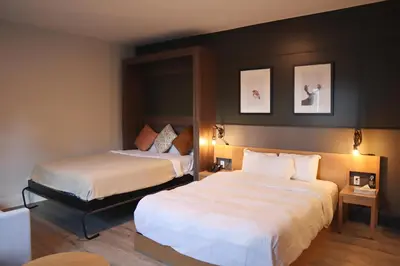 a hotel room with two beds and two pictures on the wall at Espace 4 Saisons in Magog-Orford