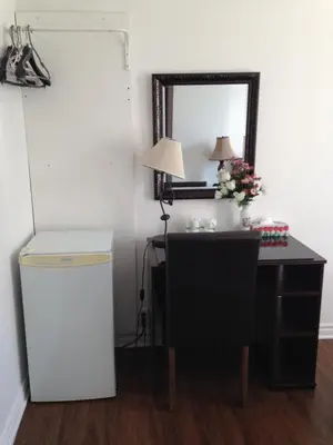 a room with a desk and a mirror and a table at Hotel Bon Accueil in Montréal