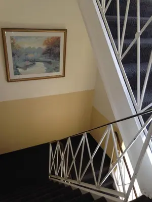 a staircase in a house with a painting on the wall at Hotel Bon Accueil in Montréal