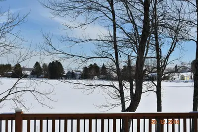 a snow covered field with a fence and trees at Domaine Henri-Daze in Saint-Pierre-Baptiste