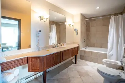 a bathroom with a sink and a tub and a toilet at Manoir Des Sables, an Ascend Collection Hotel in Magog-Orford