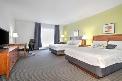 a hotel room with two beds and a flat screen tv at Hotel Le Victorin, an Ascend Hotel Collection Member in Victoriaville
