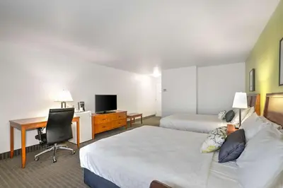 a hotel room with two beds and a desk at Hotel Le Victorin, an Ascend Hotel Collection Member in Victoriaville
