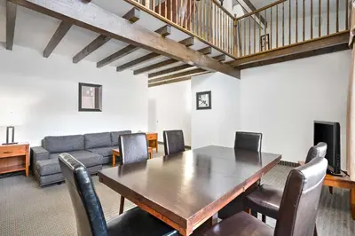 a dining room with a table and a couch at Hotel Le Victorin, an Ascend Hotel Collection Member in Victoriaville