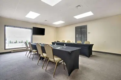 a conference room with a long table and chairs at Hotel Le Victorin, an Ascend Hotel Collection Member in Victoriaville