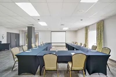 a large meeting room with a long table and chairs at Hotel Le Victorin, an Ascend Hotel Collection Member in Victoriaville