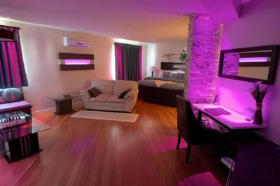 a living room with a room with purple lighting at Hotel-Motel Drummond in Drummondville