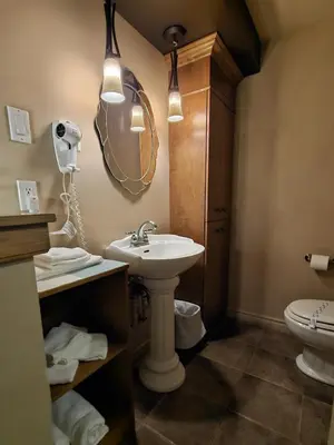 a bathroom with a sink and a mirror and a toilet at Hotel-Motel Drummond in Drummondville