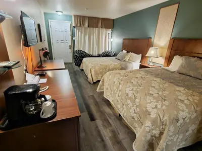 a hotel room with two beds and a television at Hotel-Motel Drummond in Drummondville