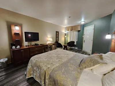 a hotel room with a bed and a flat screen tv at Hotel-Motel Drummond in Drummondville