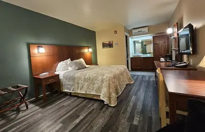 a hotel room with a bed and a flat screen tv at Hotel-Motel Drummond in Drummondville