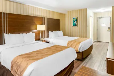 a hotel room with two beds and a television at Quality Hotel & Suites in Sherbrooke