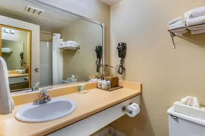 a bathroom with a sink and a large mirror at Quality Hotel & Suites in Sherbrooke