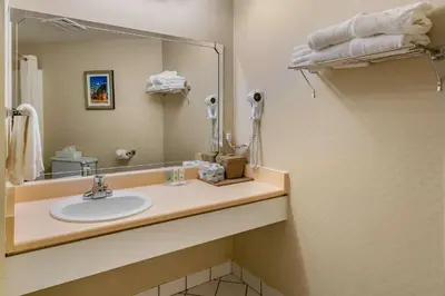 a bathroom with a sink and a mirror at Quality Hotel & Suites in Sherbrooke
